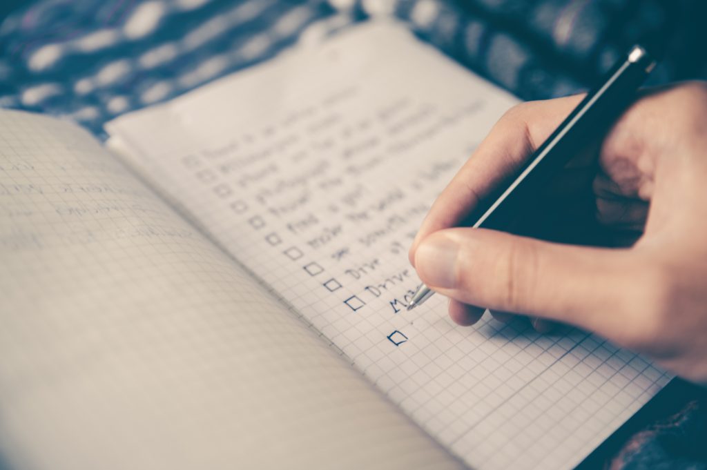 close-up shot of a person using a pen to write a to-do list