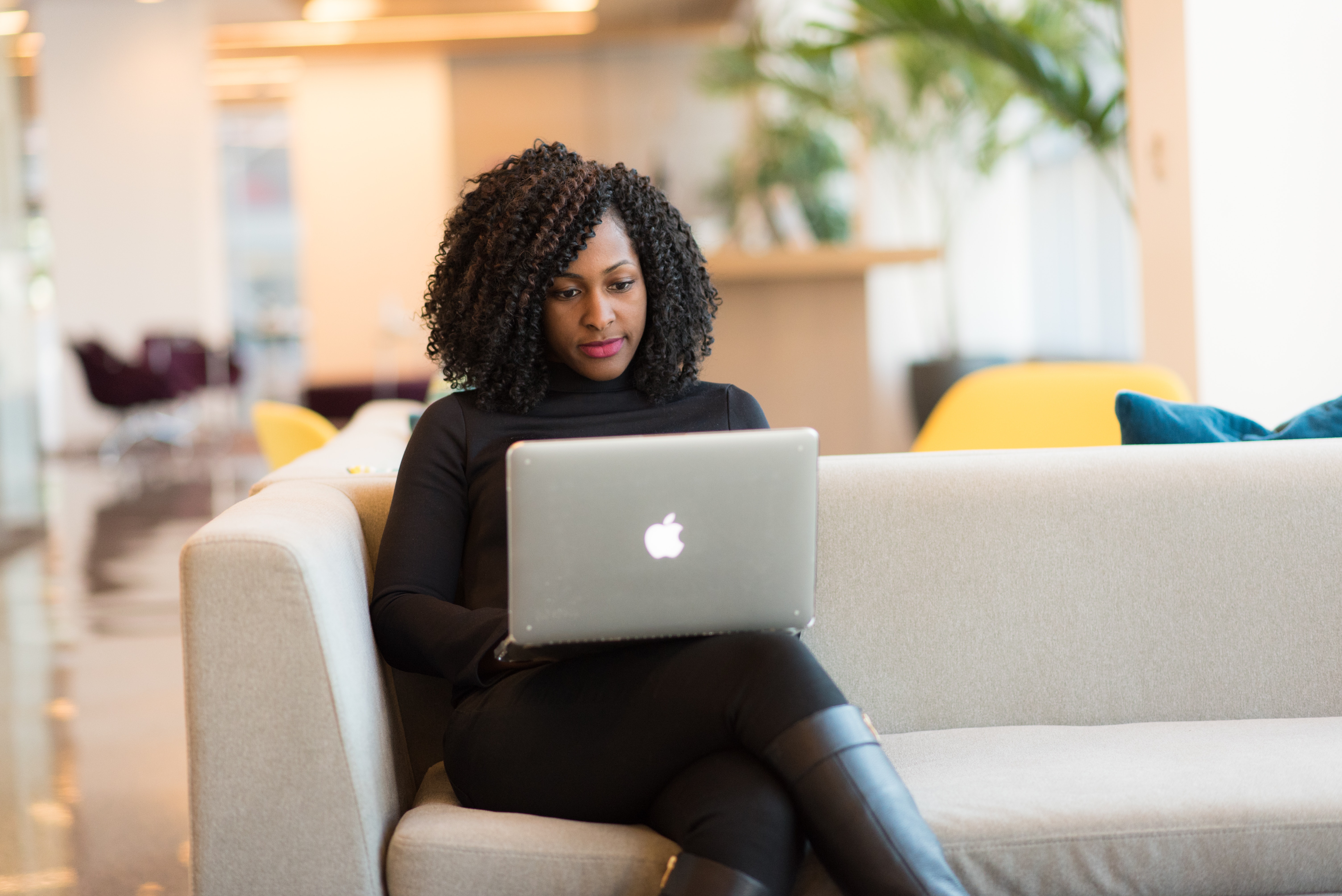 african american woman working on her laptop on the couch