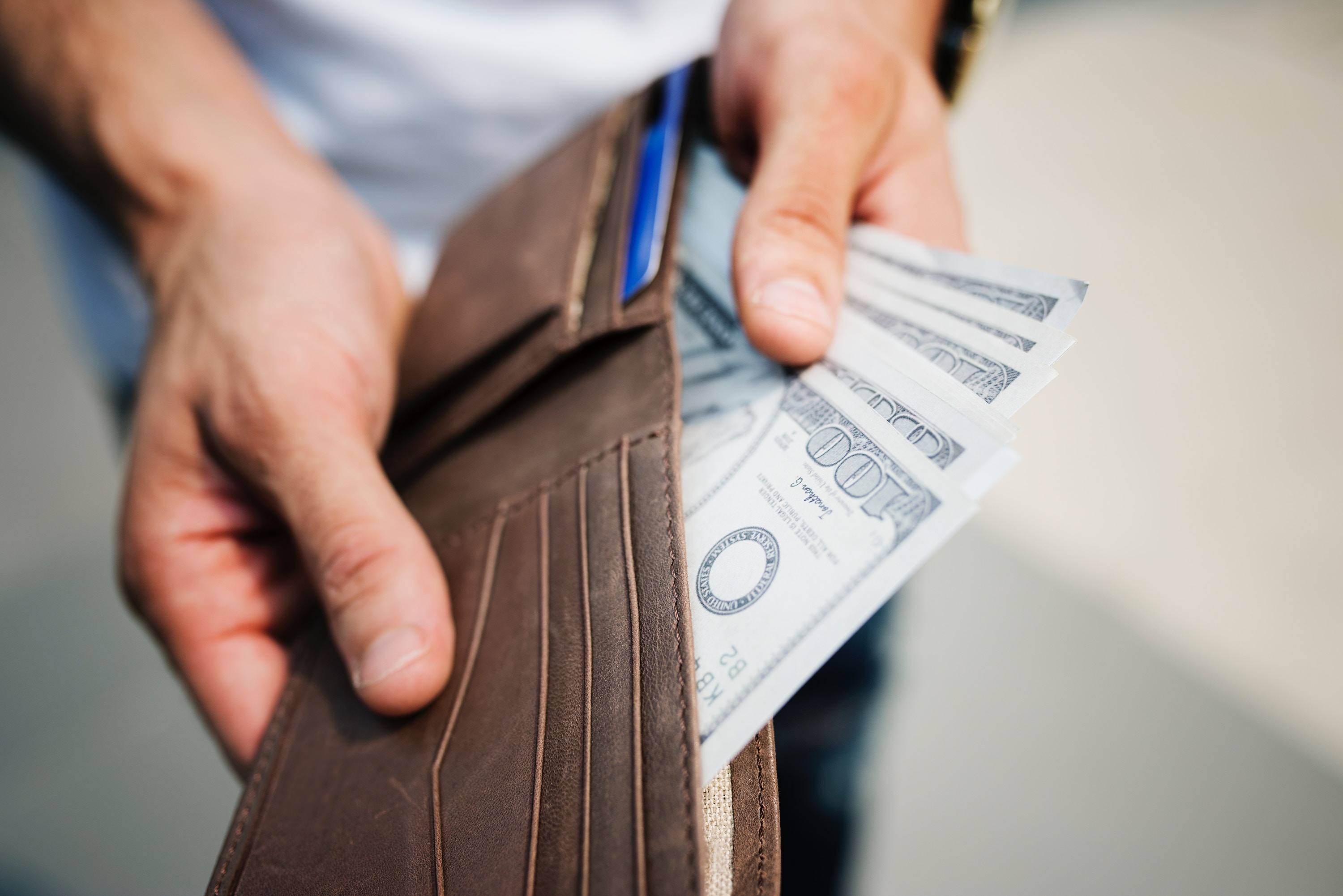 close-up shot of a person taking out dollar bills out of wallet