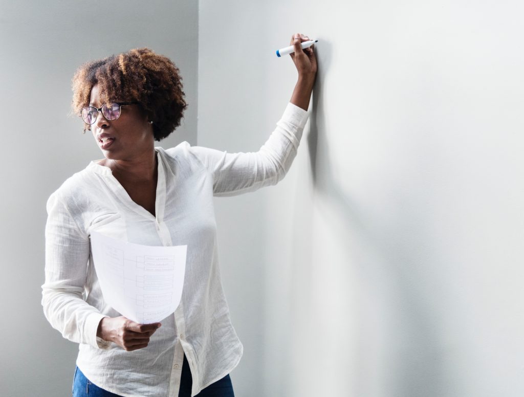 african american professor writing on a whiteboard