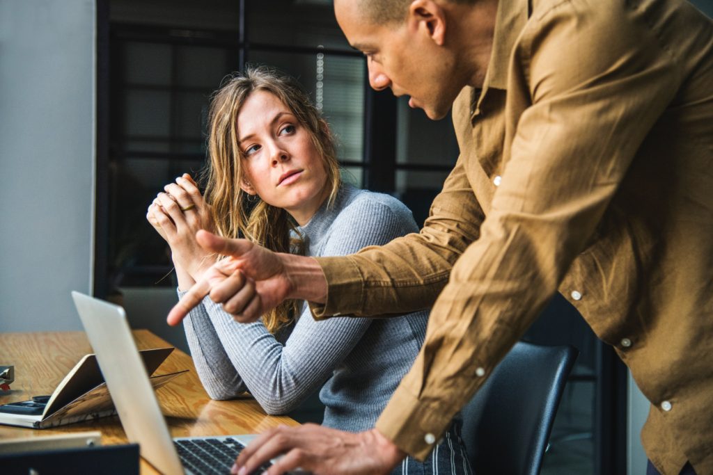 man explaining stuff on his laptop to a colleague