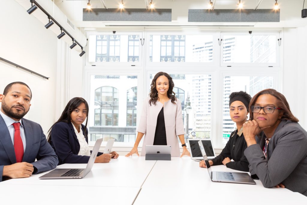 multicultural business team in a conference room all looking towards the camera