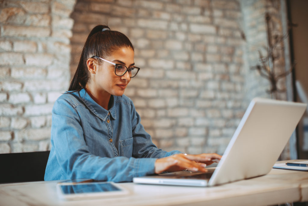 woman focused while typing on her laptop