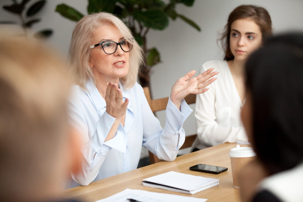 older professor explaining stuff to her students