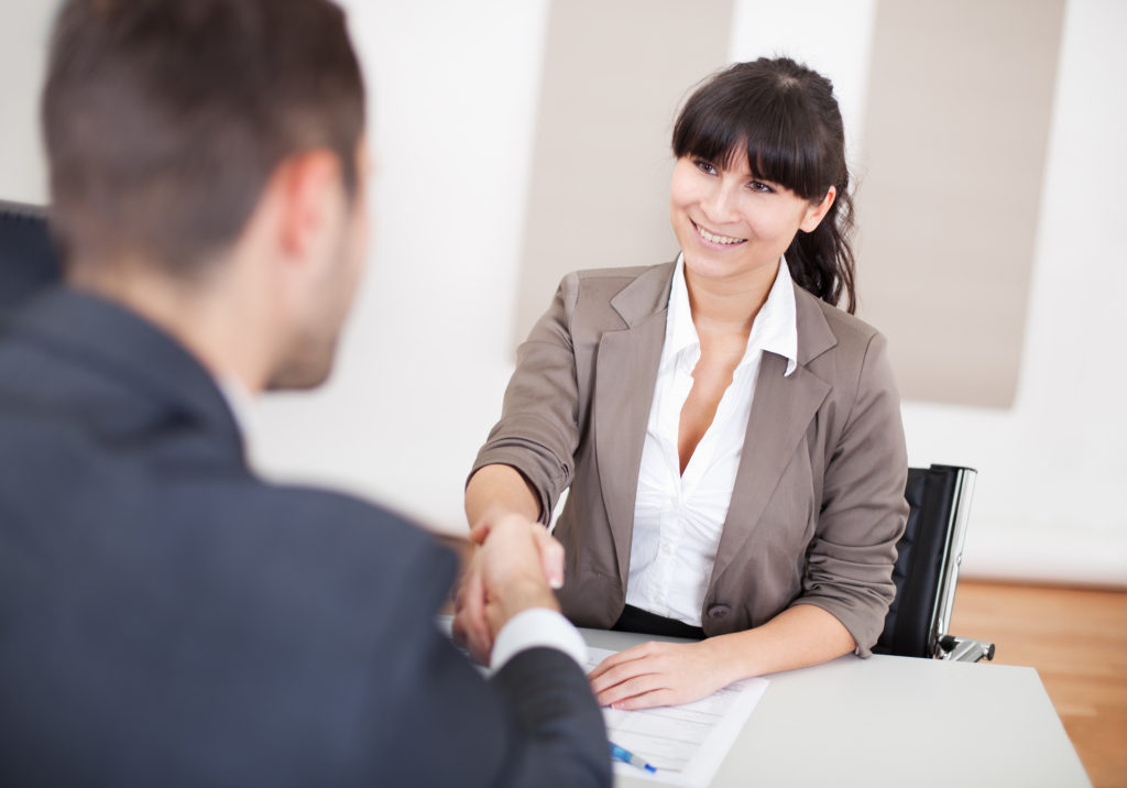 a woman and a man shaking hands in a business office