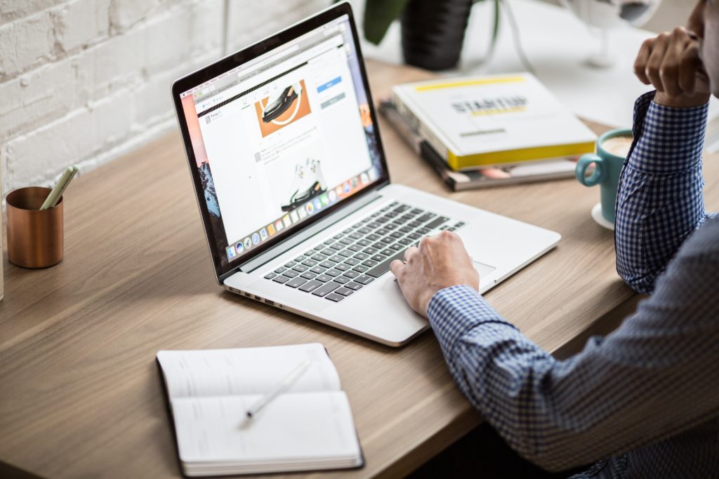 man in a blue shirt working on his laptop