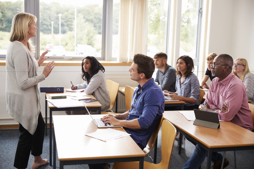 professor teaching a class to a handful of students