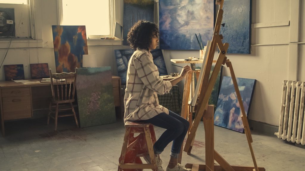 woman painting in her home gallery