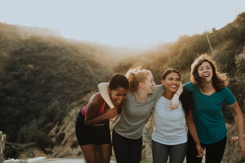 group of multicultural friends laughing together on a hike