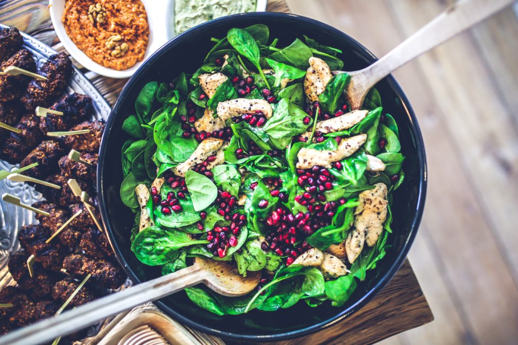 healthy green salad with pomegranate seeds