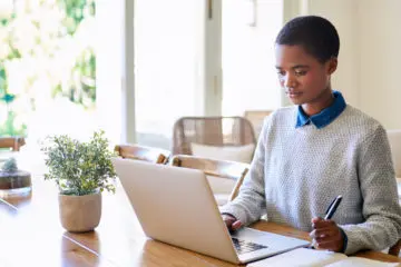 woman working on her laptop in a bright home