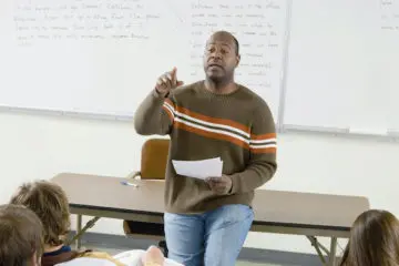 african american professor asking questions to his students