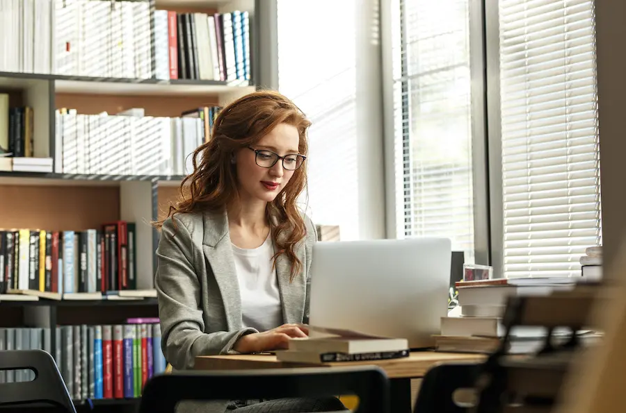 woman with red hair working on her laptop in the office