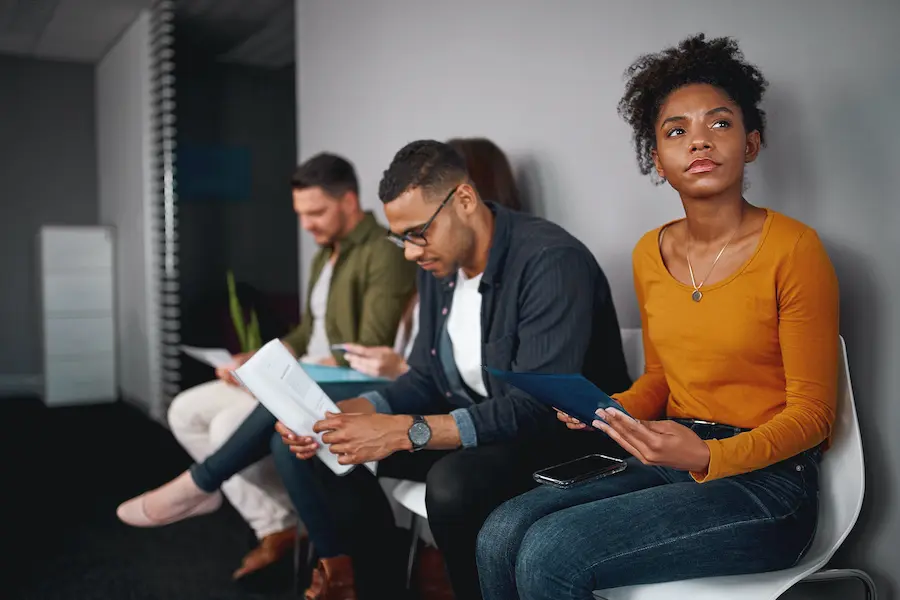 group of people worryingly waiting at a a job interview