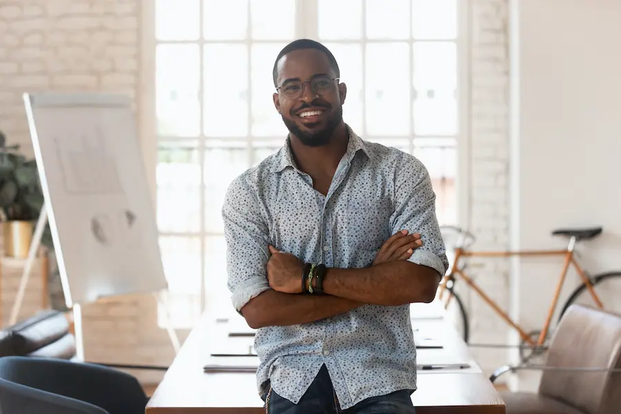 confident african american man smiling towards the camera in a bright office