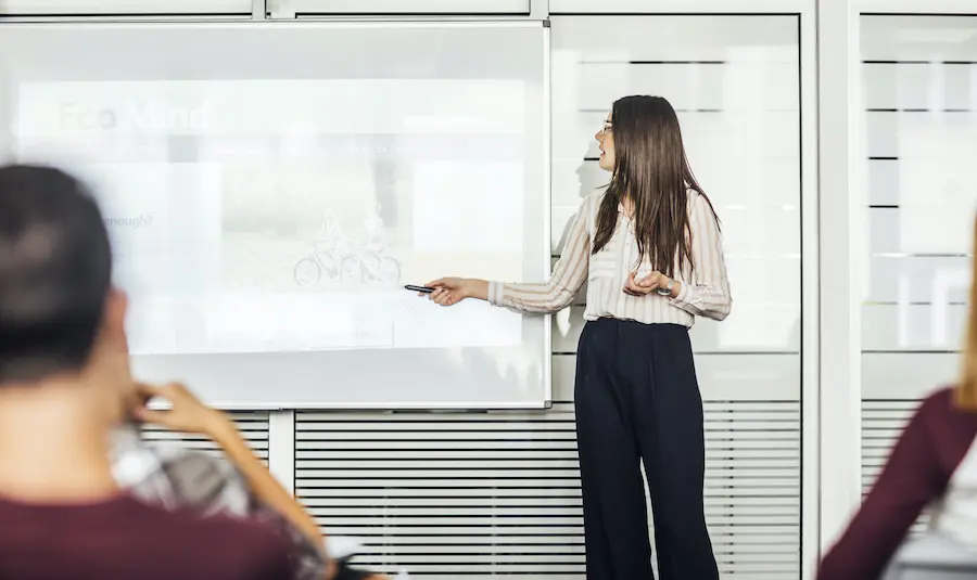 woman holding a powerpoint presentation in a bright conference room