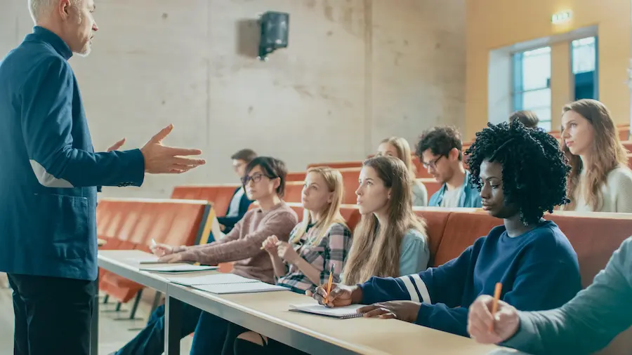 older professor holding a lecture to a small group of students