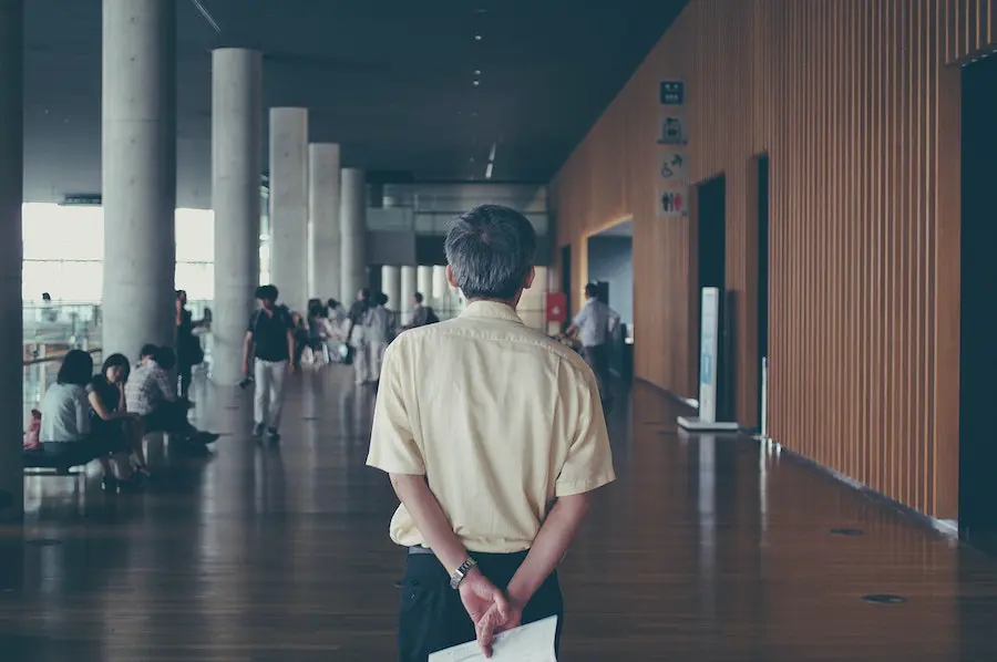 college professor holding a sheet of paper and walking through university campus