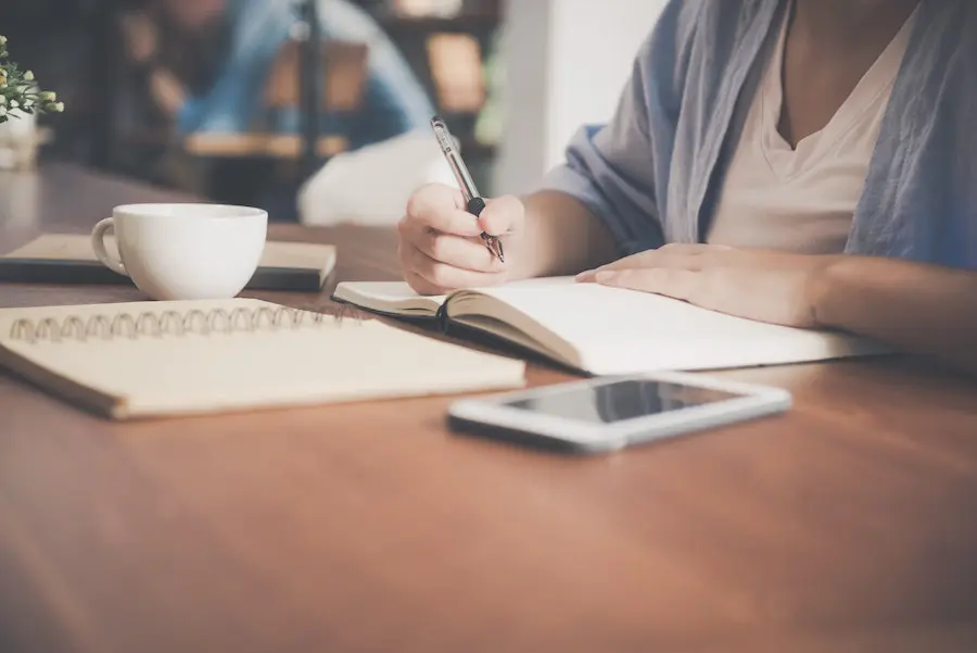 close up shot of a woman writing in her notebook