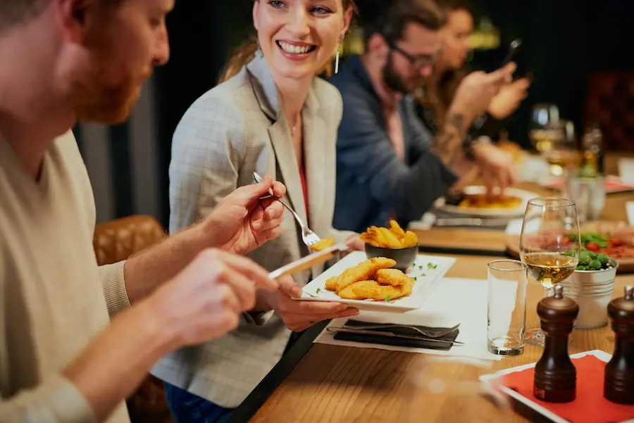 friends having dinner and smiling at the table