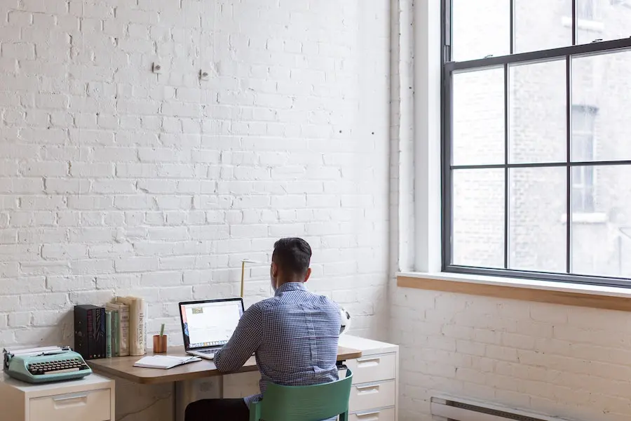 man working on his desk inside a bright home office