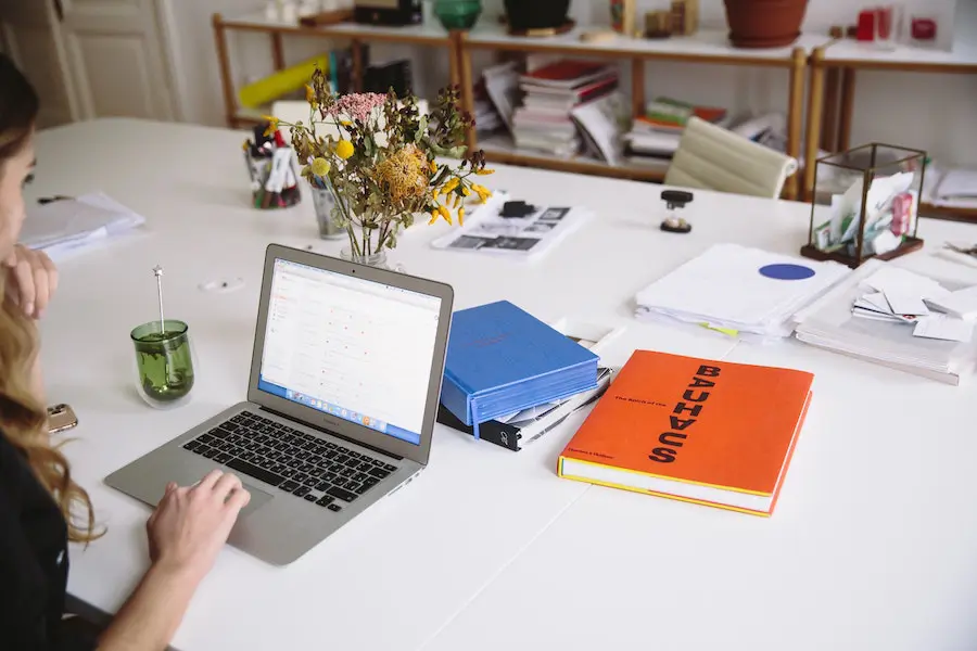 woman working on her laptop with a cup of tea next to her