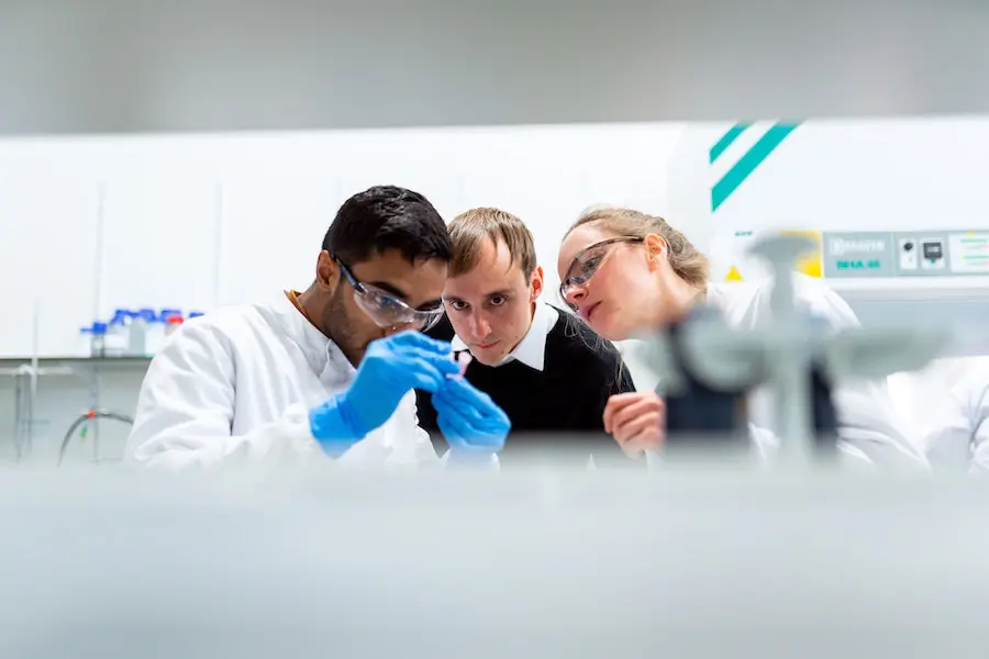 multicultural group of researchers examining samples in a laboratory