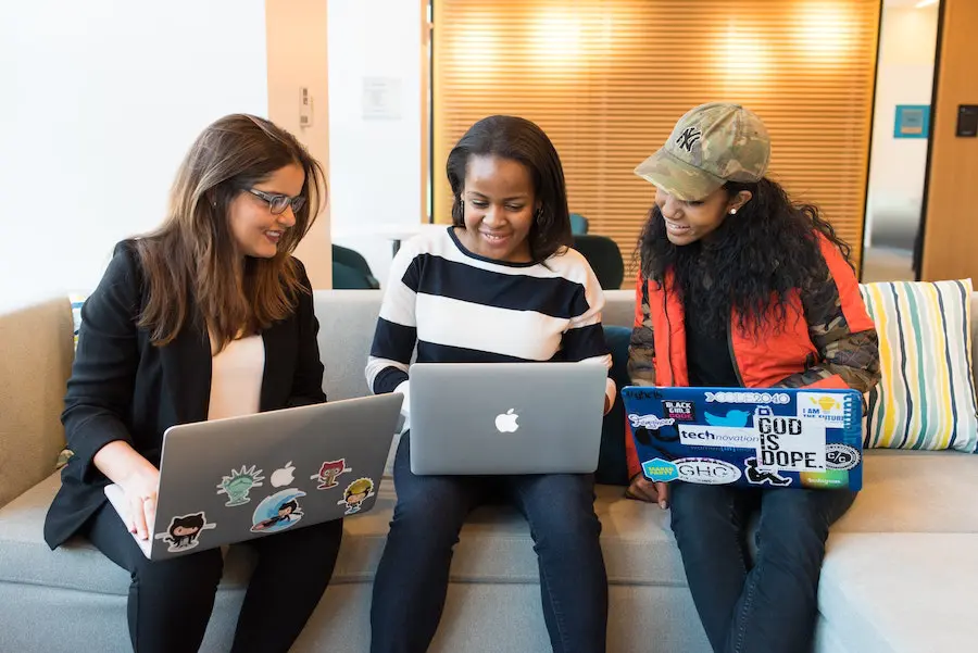 three colleagues working together on different laptops