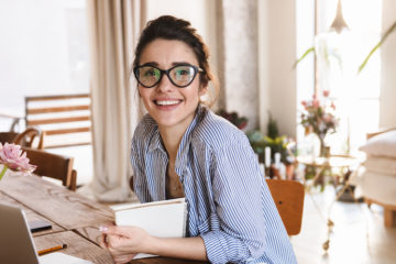 woman smiling at the camera while studying