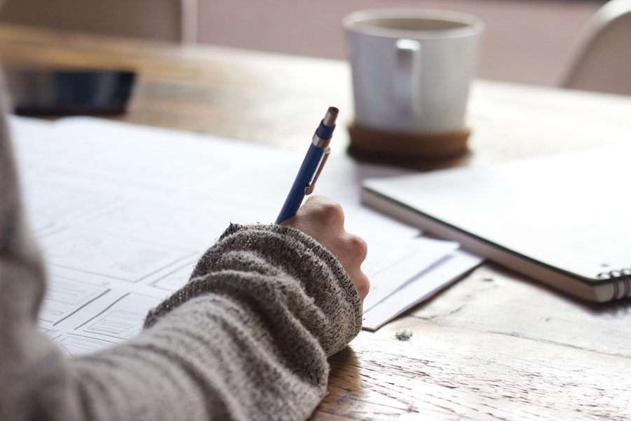 close-up shot of a person writing with a pen