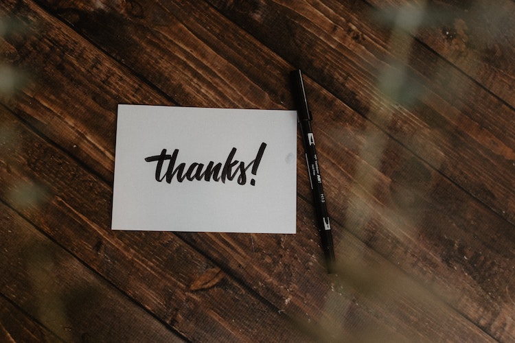 note saying 'thanks' on a wooden table