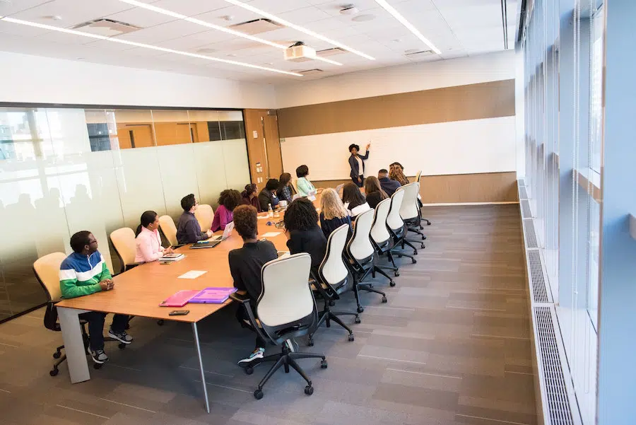 woman presenting something to a full conference room