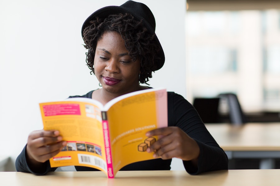 african american woman smiling and reading a book