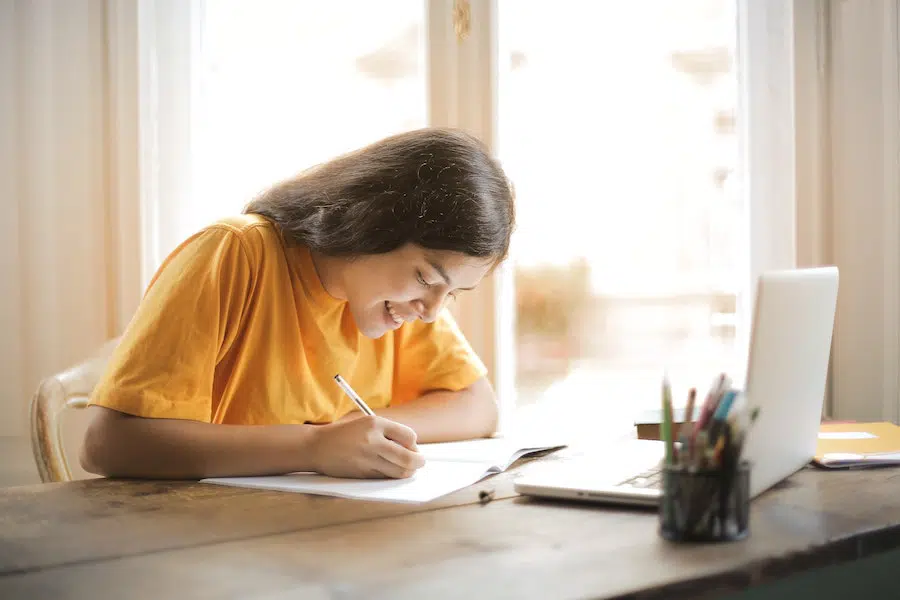 young woman in a yellow shirt studying at home