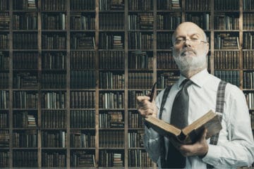 senior professor holding a book and a pipe looking arrogantly towards the camera