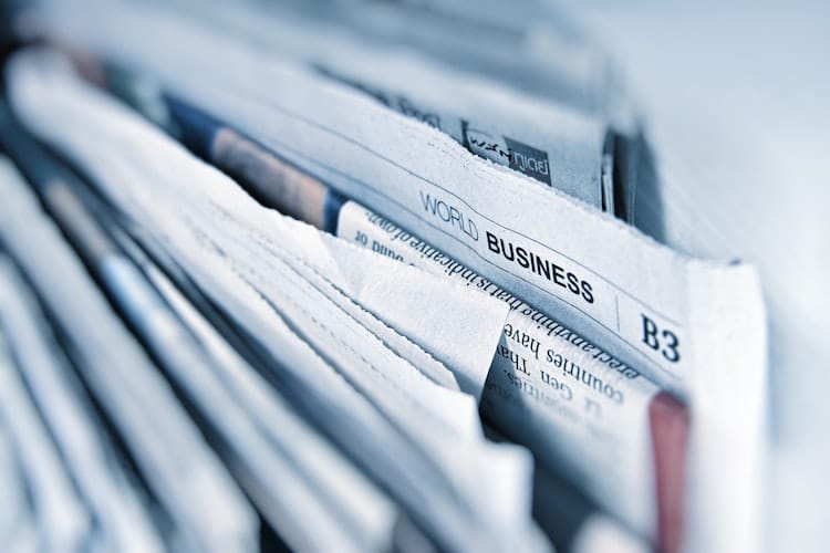 close up of stacked newspapers with the focus on world business