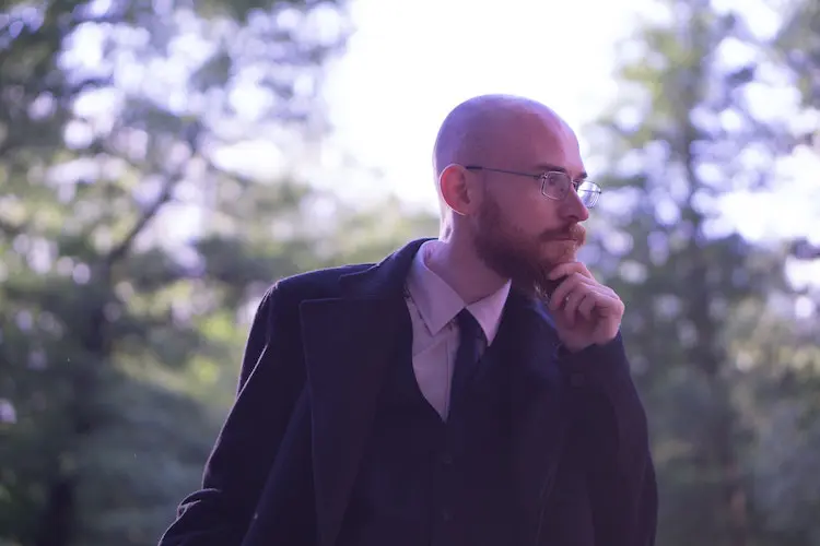 academic with eyeglasses thinking about something outdoors