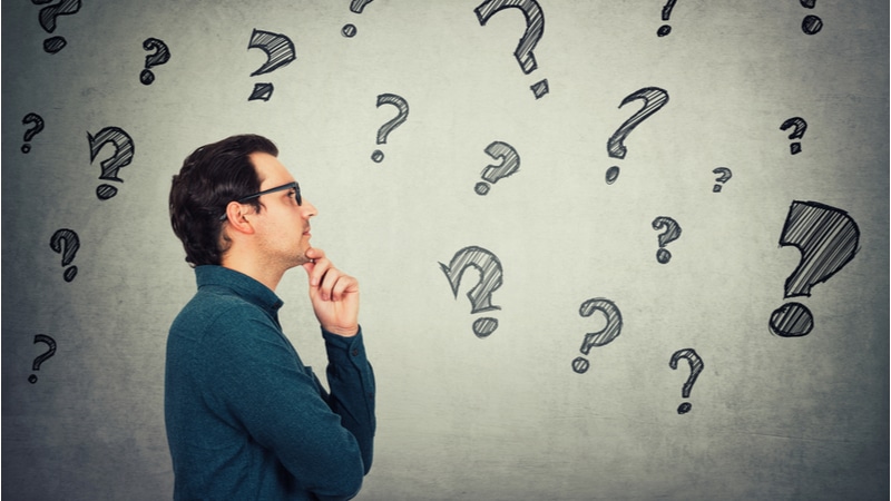 purpose of a research paper example man with eyeglasses thinking of something with question marks around him