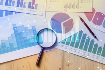 graphic of a magnifying glass over analytics charts