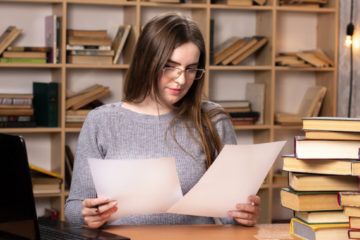 woman reading notes in a library