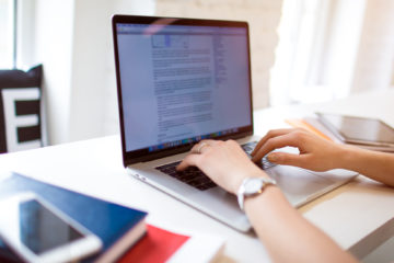 woman writing an academic paper on her laptop