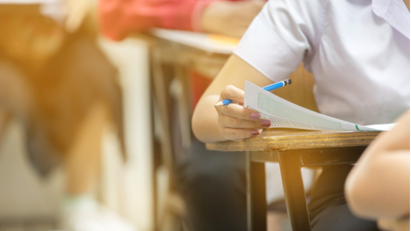 woman holding a pencil while taking an exam