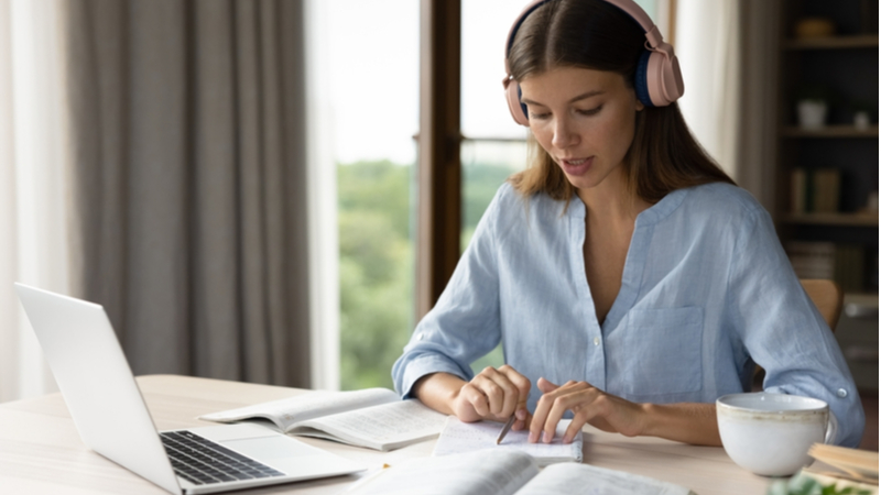 woman comparing notes between notebook and laptop