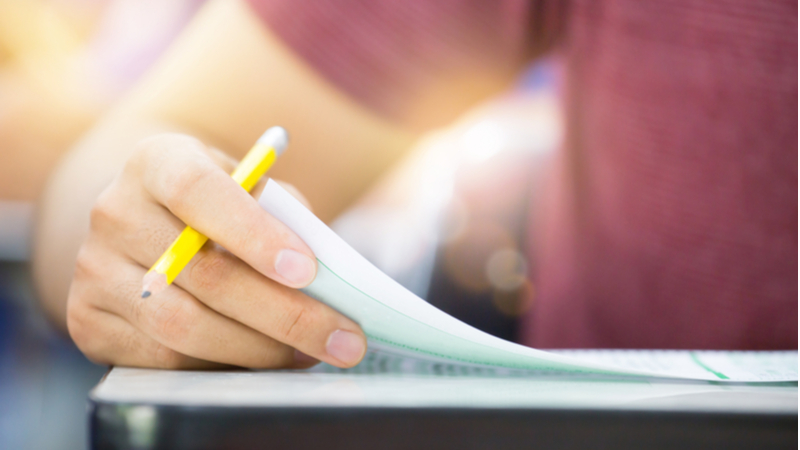 close-up shot of a man taking an exam while holding a pencil