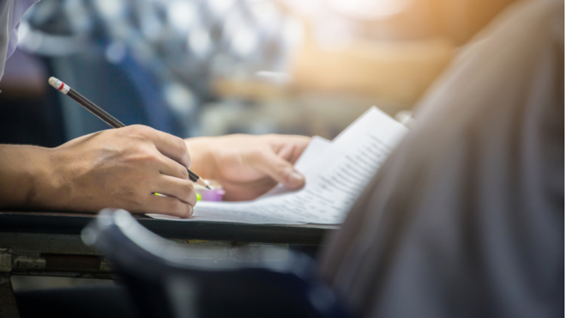 close-up of a person taking an exam using a pencil