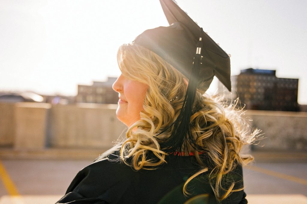 blonde woman at a master's graduation in the sunlight
