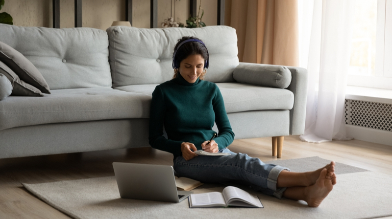 woman with headphones working on her dissertation at home