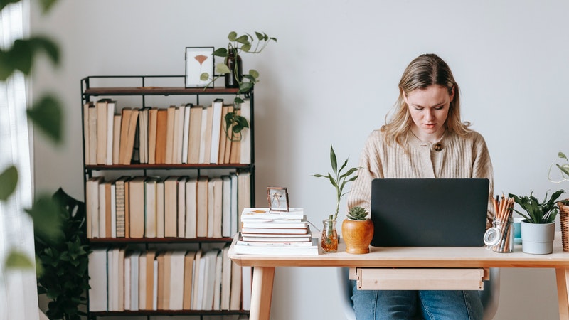 woman studying in her home office filled with plants