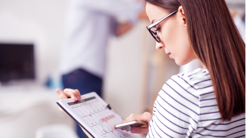 woman with eyeglasses going through her calendar