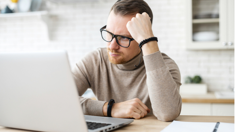 man using his laptop in his home kitchen 